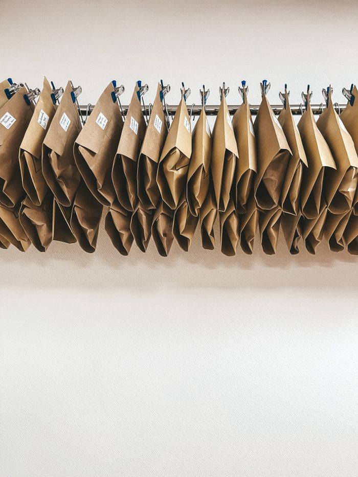 Brown packages neatly organized on metal hangers with a clean white background.
